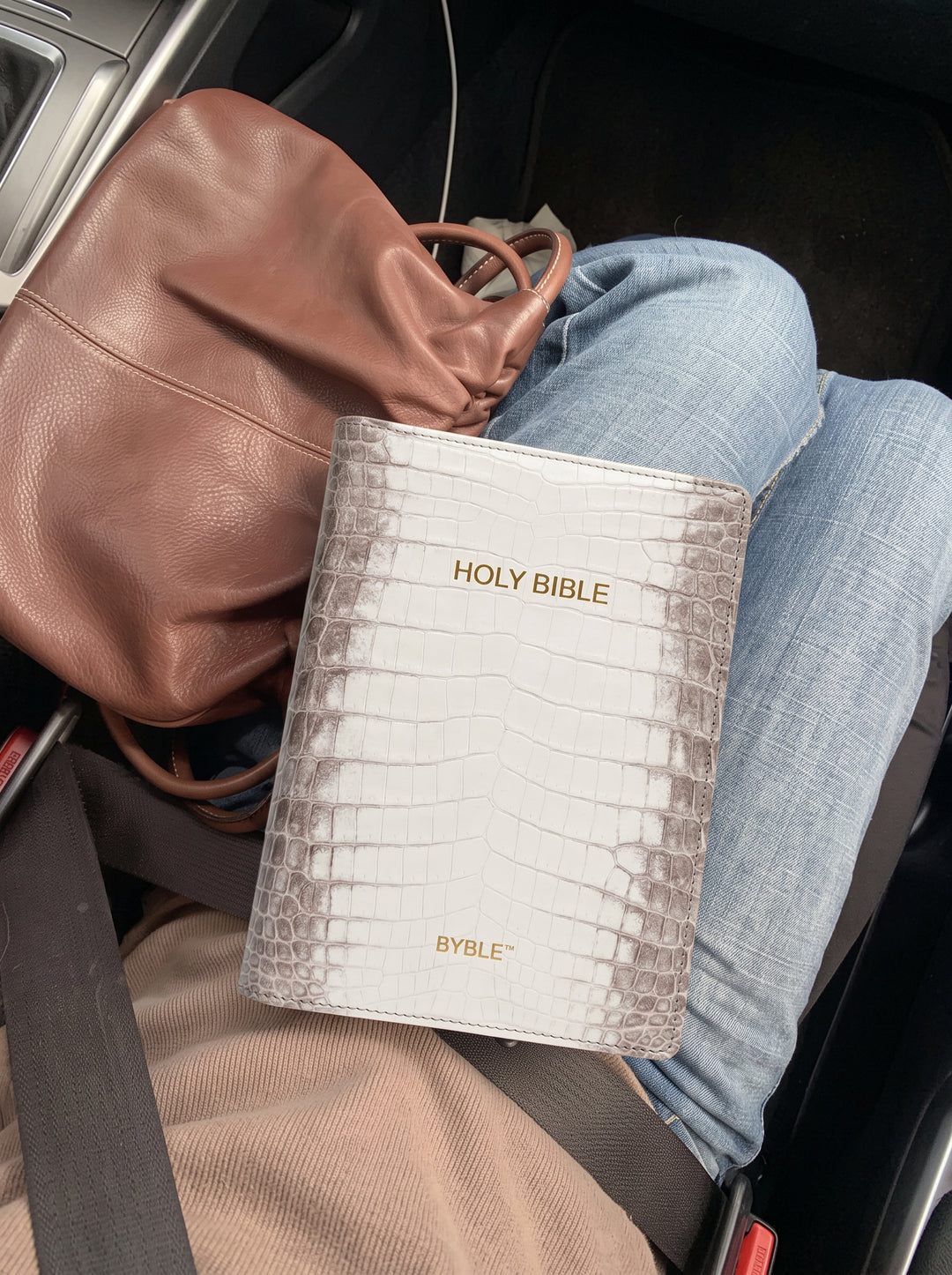 White Everyday Bible Cover held on a lap while travelling