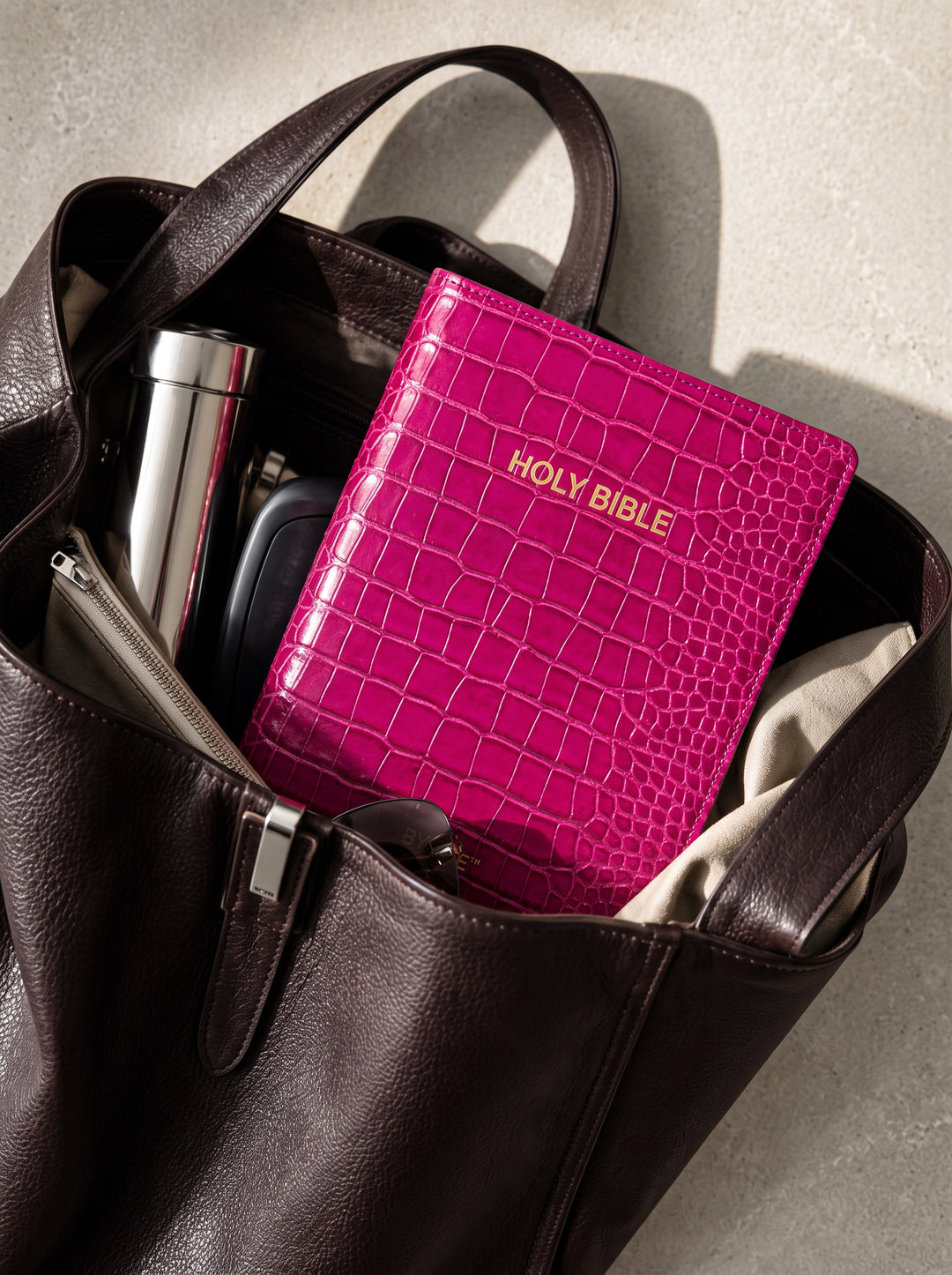 Magenta Everyday Bible Cover tucked inside a leather tote