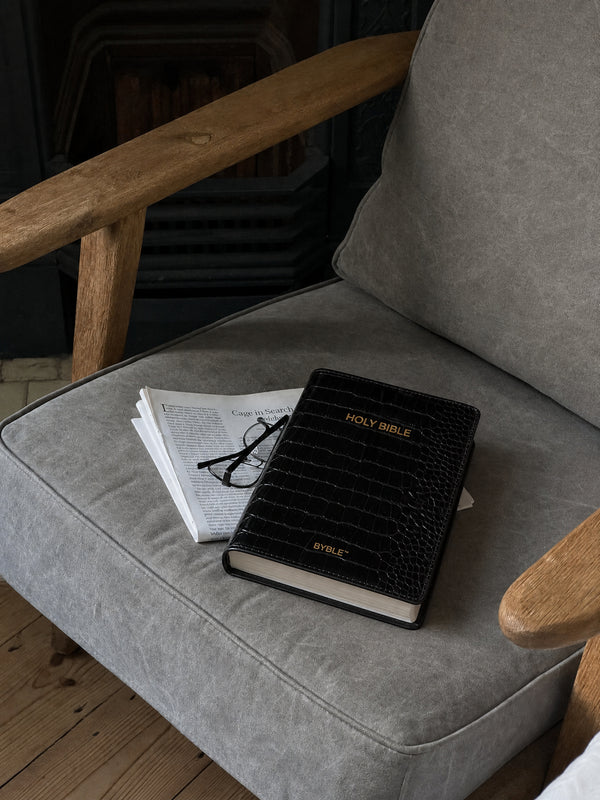 Black Everyday Bible Cover resting on an armchair